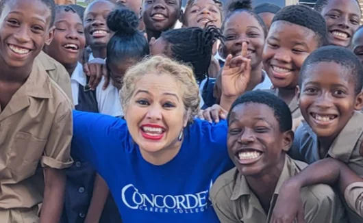 Caroline smiling with a bunch of children