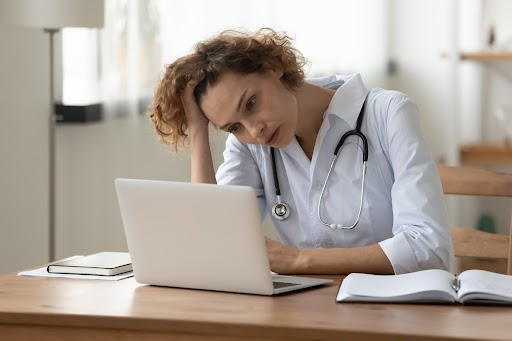 A frustrated woman looking at a laptop