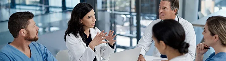 Healthcare professionals sitting around a table having a meeting